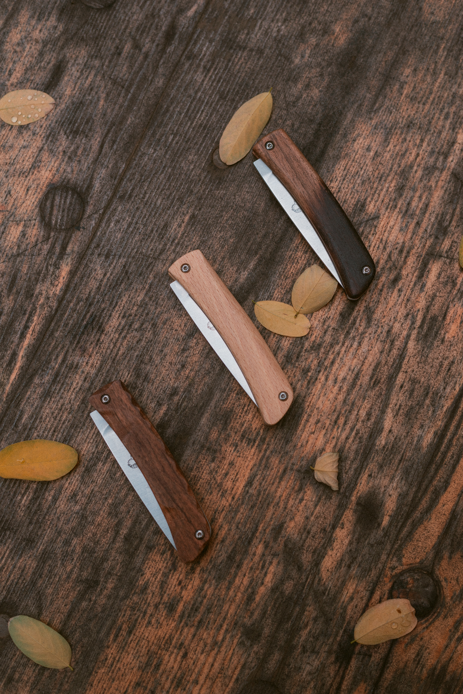 trois couteaux sur une table en bois