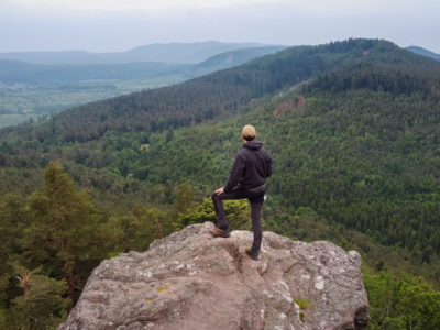 Randonneur se tenant de dos face à un panorama dans les Vosges