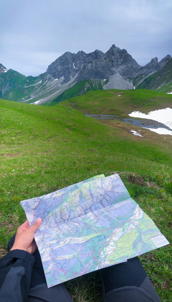 Un randonneur tient entre ses mains une carte de randonnée dans les Alpes d'Allgäu en Bavière
