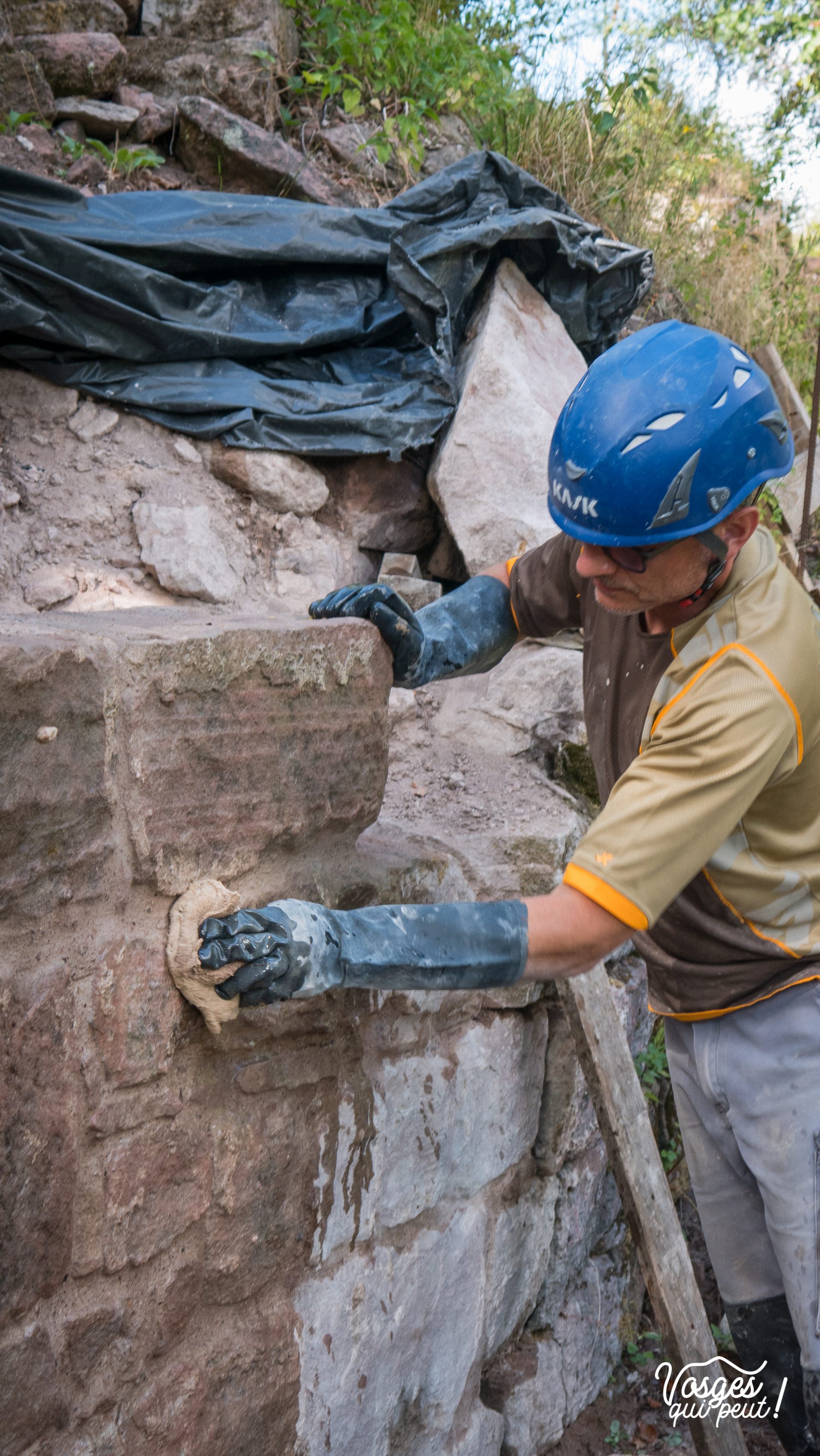 Un bénévole de l'association Les Veilleurs de Salm restaure un mur du château de Salm dans la vallée de la Bruche