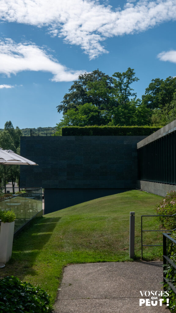 Façade contemporaine en pierre sombre du Musée Lalique avec jardins et terrasse