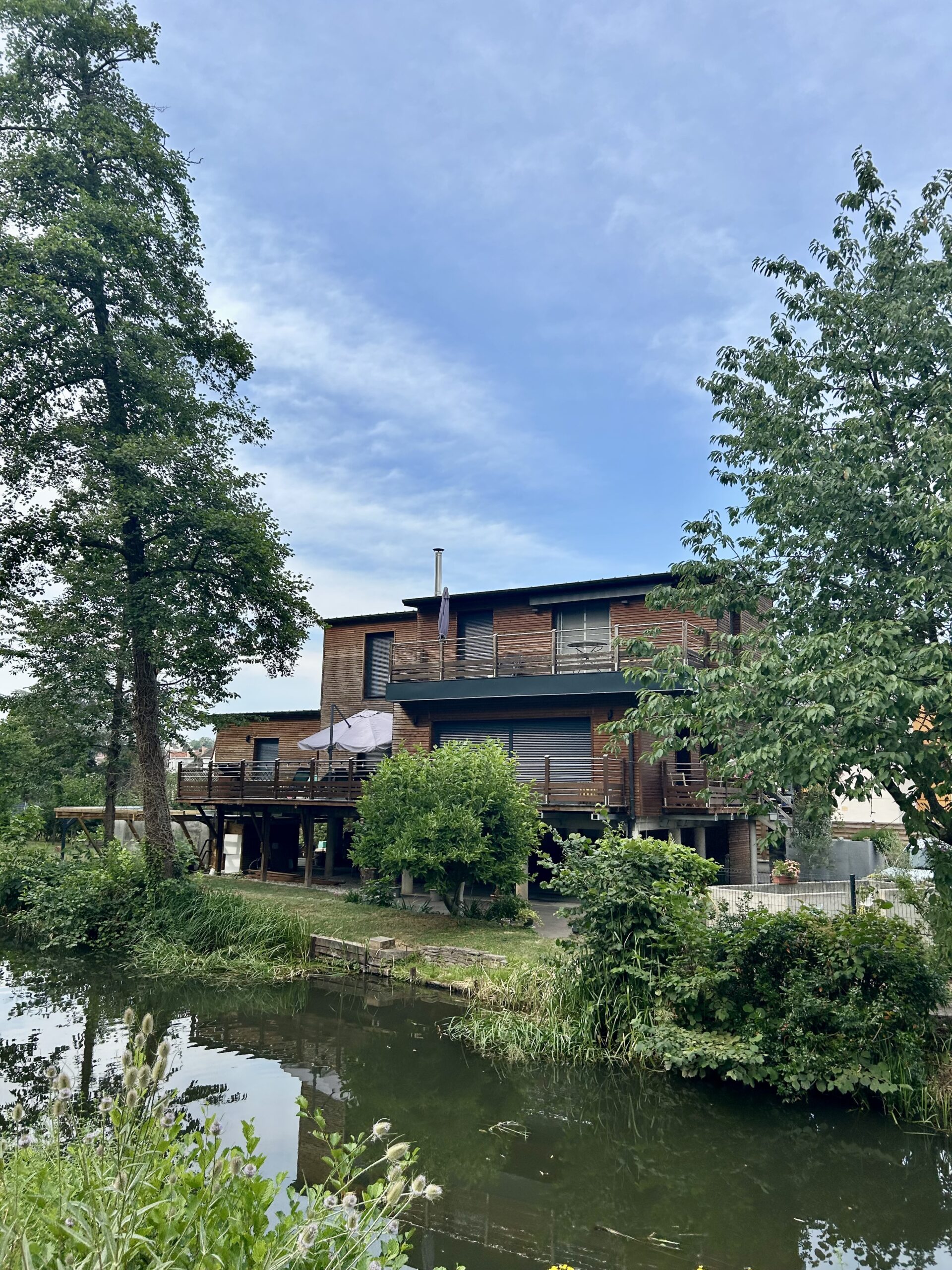 Balade poussette Strasbourg : maison en bois avec terrasse au bord du canal de la Bruche