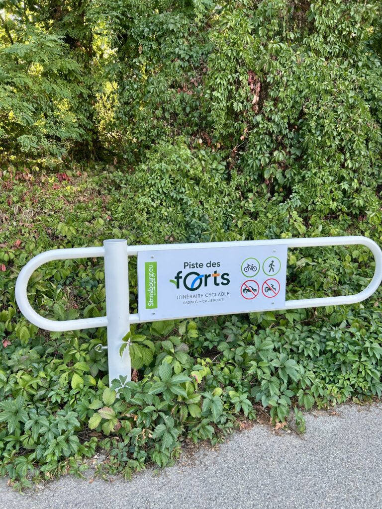 Balade poussette Strasbourg : barrière et panneau de la Piste des Forts, itinéraire cyclable ouvert aux vélos et aux piétons